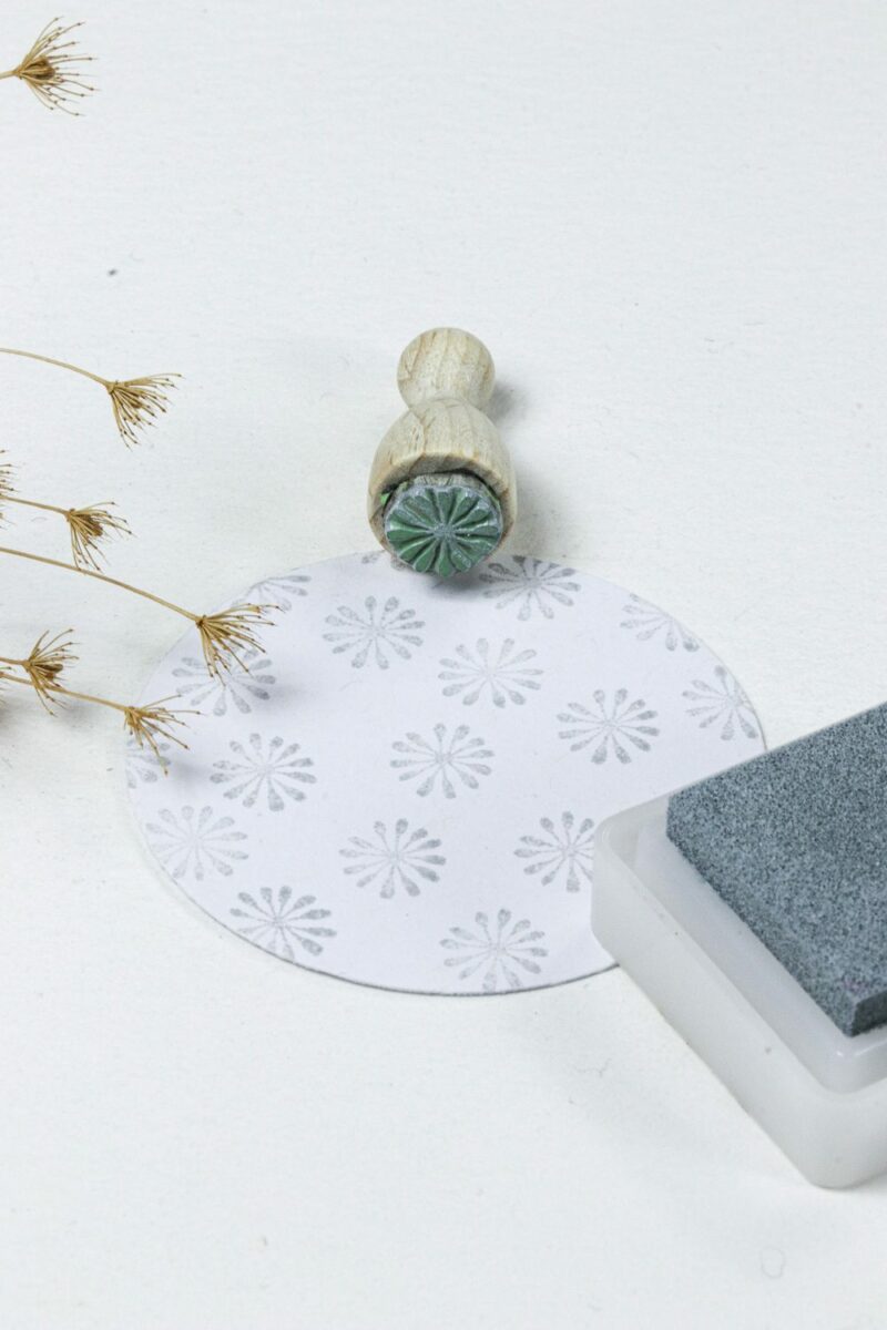 Ministempel mit kleiner Allium Blüte in grau auf einen runden Geschenkanhänger gestempelt