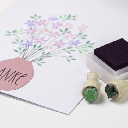 Zwei Ministempel, ein kleines Stempelkissen in dunkel lila und eine Karte mit Blumenstrauß